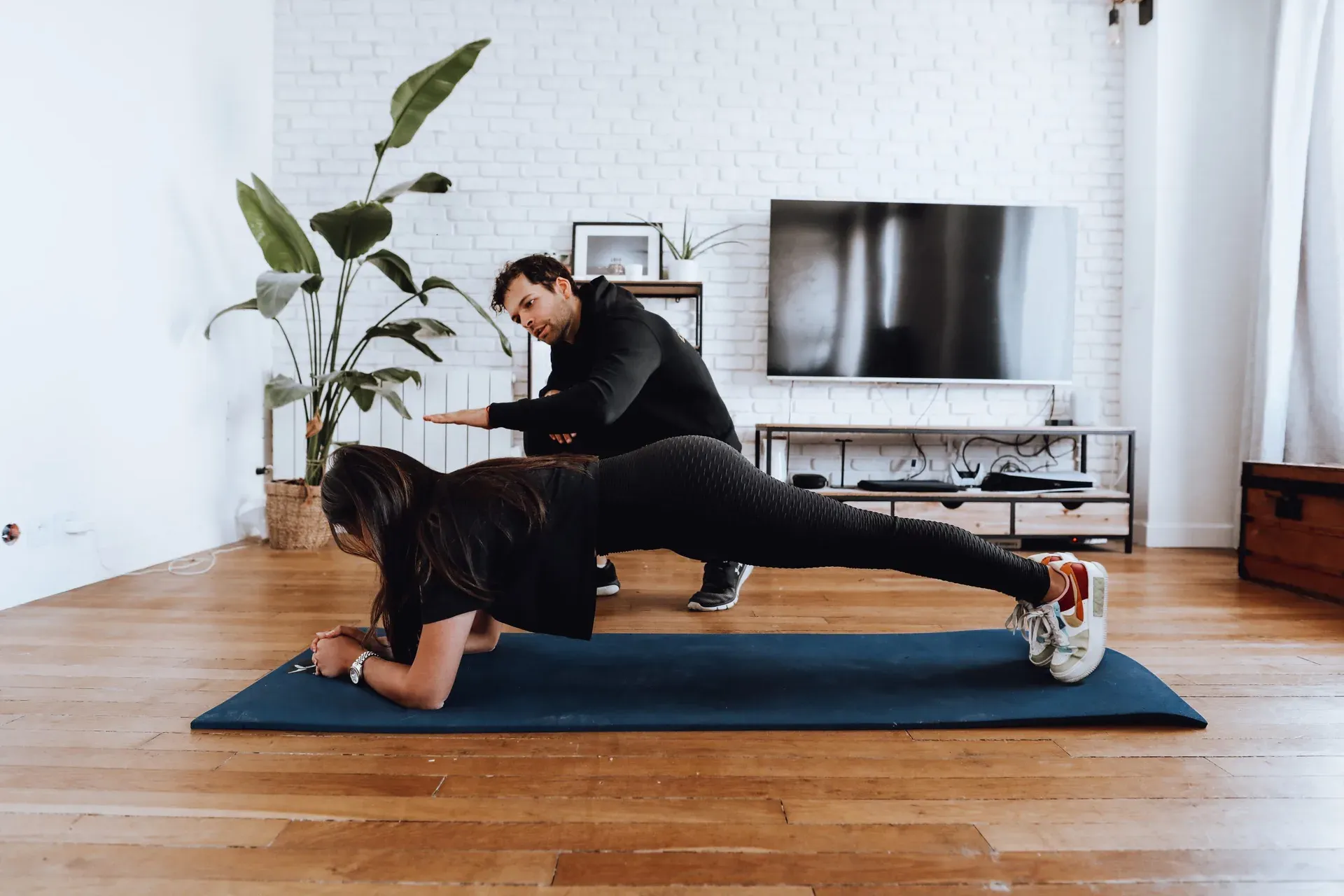 Exercice de planche avec un coach à domicile